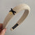 Textured Knitted Headbands with Small Black Bow and Gold-tone Charm